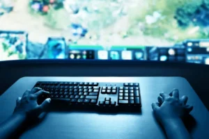 Gaming desk with a keyboard and screen under blue lighting