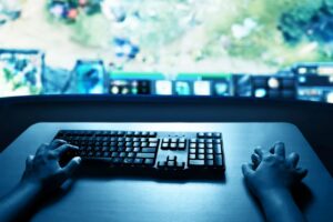 Gaming desk with a keyboard and screen under blue lighting